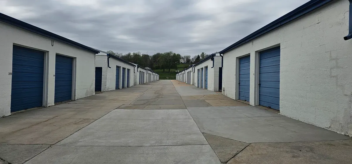 Wide driveway with drive up units and roll up doors.