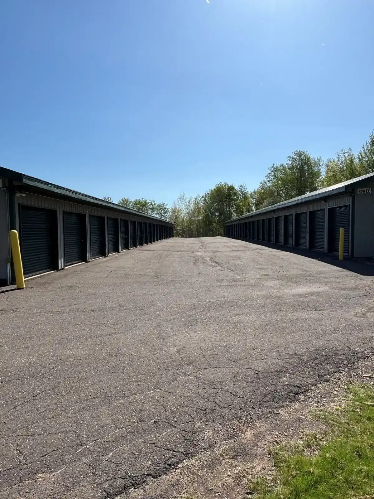 Wide driveway with drive up units and roll up doors.