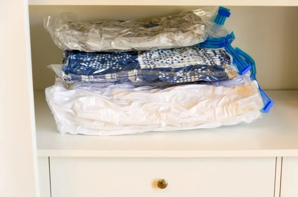 Clothes inside vacuum-sealed bags inside a dresser.
