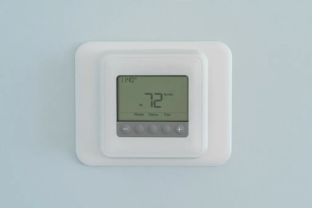 A digital wall thermostat showing a stable temperature on its screen.