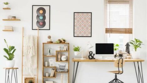 Organized home office setting with desk, computer, chair, shelves, and decorations.