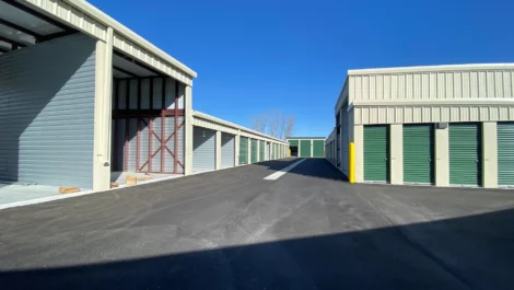 An aisle of drive-up access storage units showcasing small units and covered RV units.