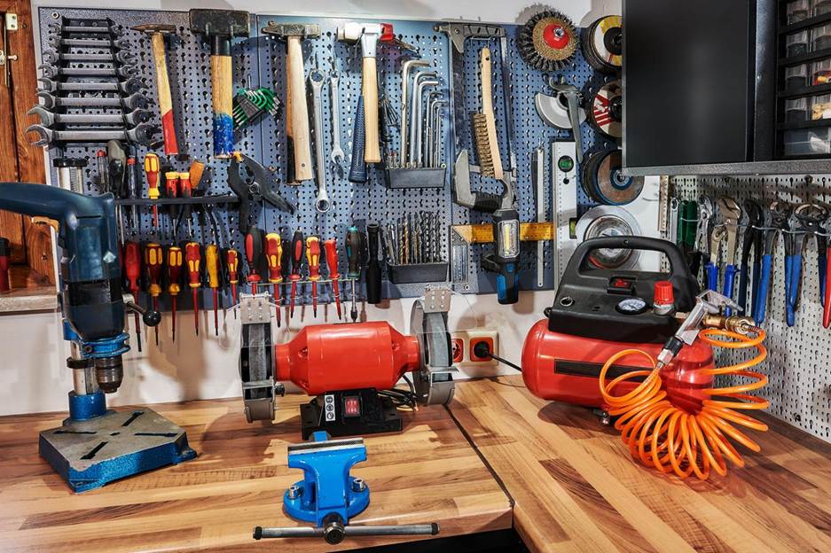A set of work tools laid out or hanging at a workstation in someone’s garage.