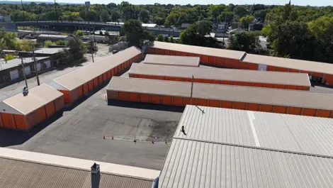 Aerial view of the Five Star Storage facility in St. Paul, Minnesota, showing the well-organized rows of storage units, the parking area, and a view of the adjacent residential area with houses and trees.