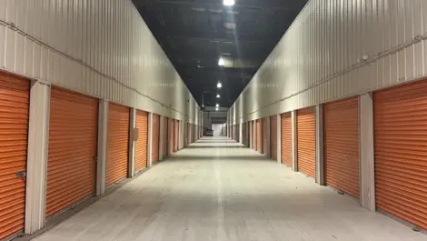 Interior view of a clean and well-lit hallway inside the Five Star Storage facility on Marshall Avenue, St. Paul, featuring beige walls, individual storage unit doors, and a smooth concrete floor.